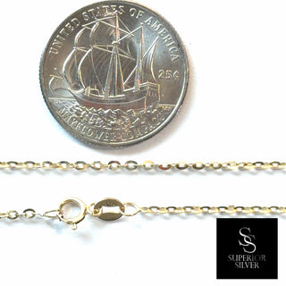 Superior Silver 10K yellow gold 1.6mm flat cable link chain with a spring ring clasp, shown next to a US quarter.