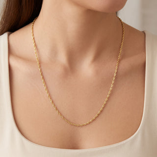 Superior Silver 24-inch Singapore link chain in solid 10K yellow gold worn around a woman's neck