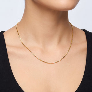 Superior Silver 16-inch 14K yellow gold box link chain necklace worn on a model, featuring a delicate 0.9mm width.