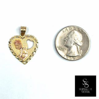 Superior Silver 14K yellow gold heart-shaped pendant with floral detailing next to a US quarter for scale.