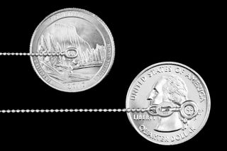 Superior Silver 1mm diamond-cut bead chain in 925 sterling silver shown next to US quarters for scale.