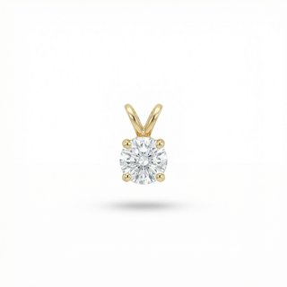 Gold pendant with a clear gemstone on a white background