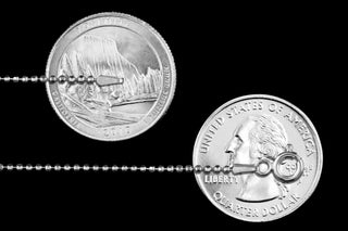 Superior Silver 1.2mm diamond-cut bead chain in 925 sterling silver shown for scale against US quarters
