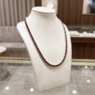 Superior Silver round cut garnet tennis chain in 925 sterling silver displayed on a beige jewelry bust