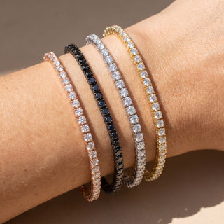 Superior Silver stack of four moissanite tennis bracelets in rose gold, black rhodium, white gold, and yellow gold.