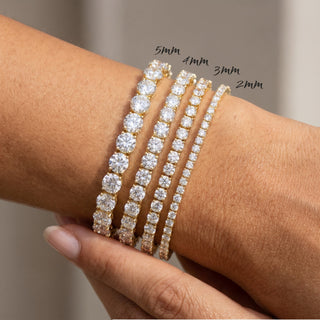 Superior Silver moissanite tennis bracelets in gold vermeil, shown in 2mm, 3mm, 4mm, and 5mm sizes on a wrist.