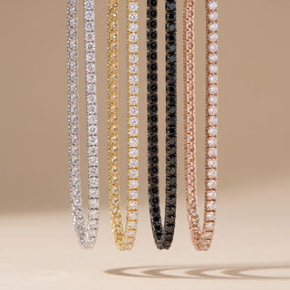 Superior Silver moissanite tennis bracelets in silver, gold, black rhodium, and rose gold finishes hanging vertically.