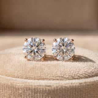 Superior Silver Portuguese cut moissanite stud earrings in rose gold vermeil with four-prong settings on velvet.