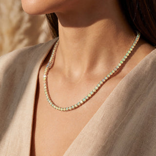 Superior Silver round cut Ethiopian opal tennis chain in sterling silver worn on a model, with green and orange fire.