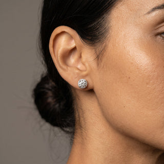 Superior Silver 7mm round moissanite halo stud earrings in rhodium-plated sterling silver worn on a model's ear.