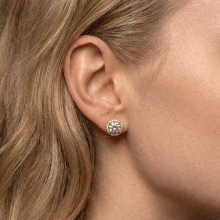Superior Silver 7mm round moissanite halo stud earrings in gold vermeil worn on a woman's earlobe
