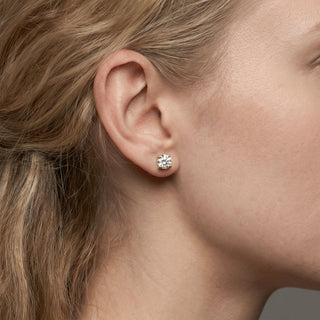 Superior Silver 6mm round moissanite solitaire stud earring in sterling silver worn on a woman's earlobe
