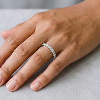 Thin Shared-Prong Half Eternity Band Moissanite Ring in sterling silver, worn on hand