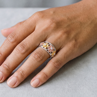 Three-Tone Five-Petal Flower Openwork Band Moissanite Ring in three-tone sterling silver, worn on hand