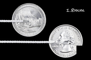 1.8mm Twisted Roc - Criss Cross Bracelet in Sterling Silver shown next to US quarters for size